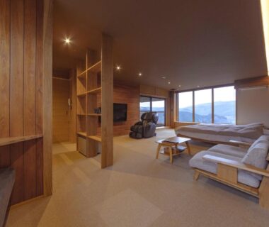 Wood-paneled lounge with sofas and large windows overlooking mountains at Magohachi, Gifu, Chūbu