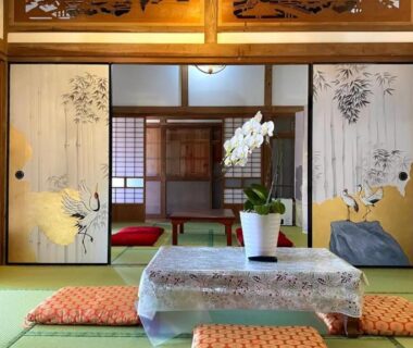 Tatami room with low table, zabuton cushions and orchid at Ichishuku Ikkei Isshōen, Chiba