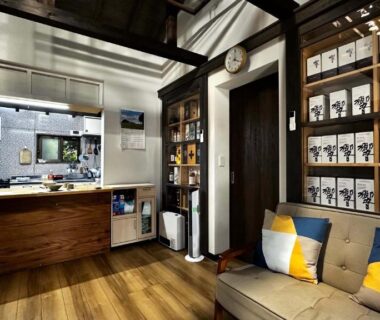 Cozy lounge with sofa, wooden counter and labeled shelves at Ichishuku Ikkei Isshōen, Ichihara Chiba