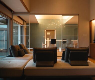 Low seating lounge with glass partition and warm wood interiors at Miwa to Sora, Ōita, Kyūshū