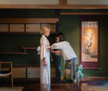 Woman assisted into kimono in tatami room at Miwa to Sora, Ōita