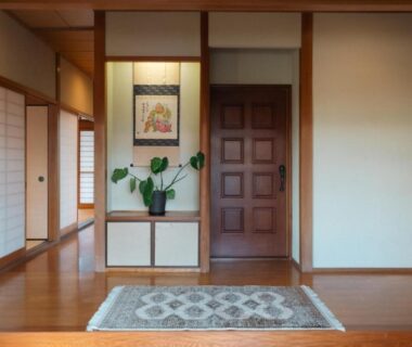 Traditional genkan with wooden floor, step up to tatami corridor, shoji screens and tokonoma alcove with plant