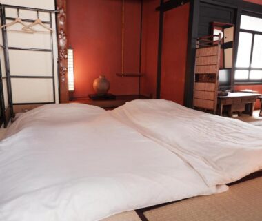 Twin futons on tatami with shoji screens and wooden interior at Kabukiya in Hiroshima