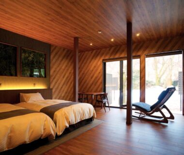Wood-paneled twin bedroom with lounge chair and sliding doors, Ichisui-sō, Niigata, Chūbu, Japan