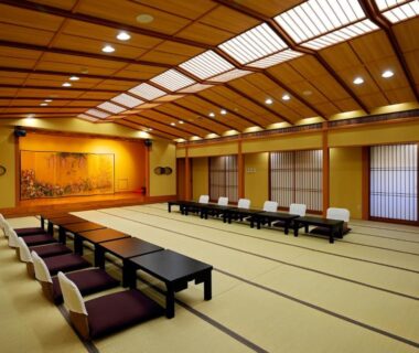 Spacious tatami banquet room with low tables, floor cushions and shoji screens at Sanpei-sō in Shizuoka
