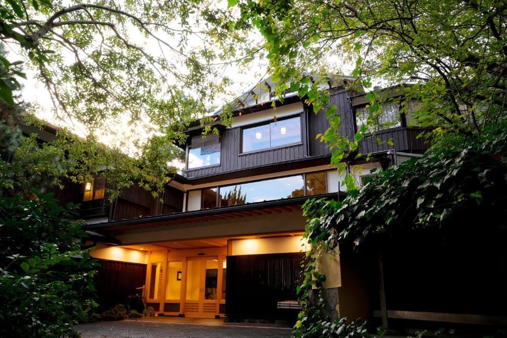 Wooded entrance Sanpei-sō Shizuoka Japan Evening view of Sanpei-sō entrance framed by trees and warm exterior lighting