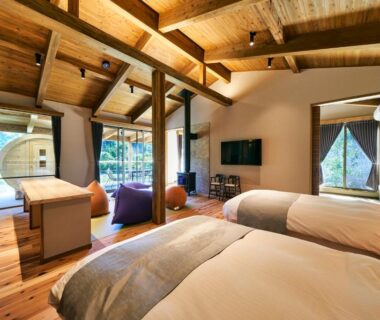 Twin beds, exposed wooden beams, seating area and garden view at 五氣里-itsukiri- in Chiba, Kantō Japan