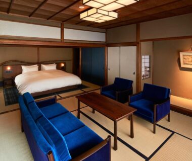 Tatami room with low table, blue seating and Western bed at Kyo no Yado Ishihara Kyoto