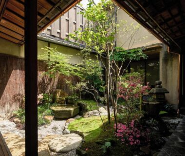 Enclosed ryokan courtyard garden with moss, stepping stones, stone lantern and wooden eaves at Kyo no Yado Ishihara Kyoto