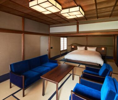 Tatami-floored room with futon bed, blue sofa set, shoji screens and wooden ceiling at Kyo no Yado Ishihara Kyoto