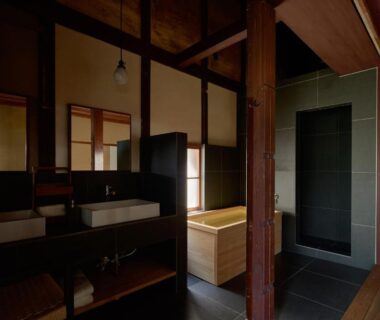 Dark tiled bathroom with wooden ofuro tub, dual basins and sliding wooden window panels at Kyo no Yado Ishihara, Kyoto