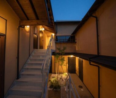 Dusk courtyard with wooden staircase and lanterns at Matsutani ryokan, Kyoto