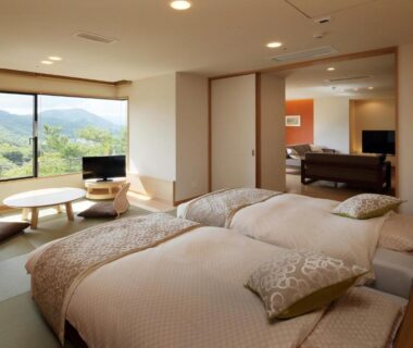 Twin beds on tatami with low table and mountain view at Ryokusuitei Sendai Akiu Onsen