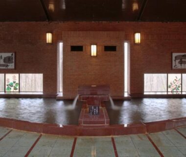 Spacious indoor onsen pool with wooden accents and windows at Ryokusuitei, Sendai Akiu Onsen, Miyagi