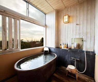 Wooden indoor onsen tub with shower and window view at 伊豆高原の隠れ宿Syuhari守破離 Shizuoka