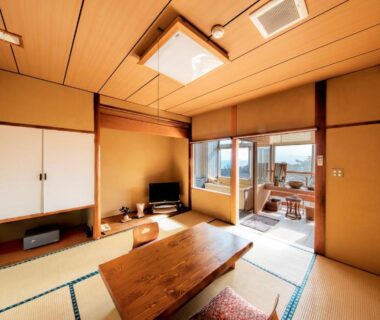 Japanese tatami room with low wooden table, shoji screens and sliding glass doors at Syuhari守破離 in Shizuoka