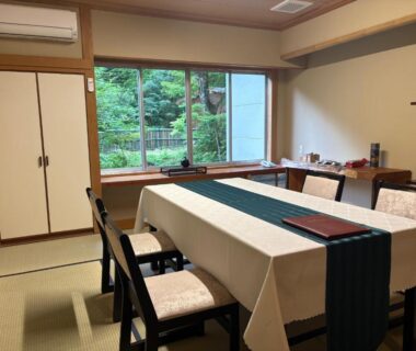 Tatami dining room with table, chairs and garden view at Shinobu Onsen Seishū, Fukushima