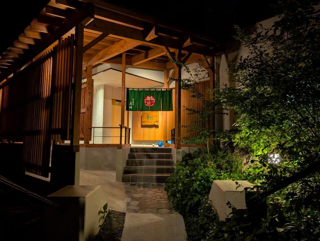Illuminated entrance Shinobu Onsen Seishū Fukushima Wooden ryokan entrance with green noren and stone steps at Shinobu Onsen Seishū, Fukushima