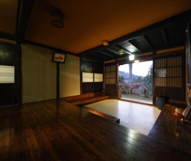 Wooden interior with shoji screens and sunken seating opening to garden view at 信州の古民家宿 真秀ろばmahoroba Nagano