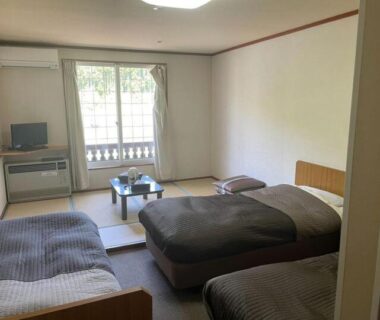 Tatami seating area with low table and three beds at Iriyamato, Nagano, Chūbu