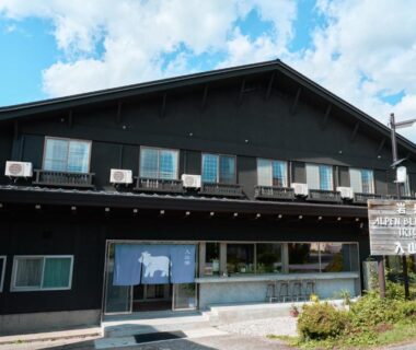 Two-story wooden ryokan with blue noren at Iriyamato in Nagano Chūbu region