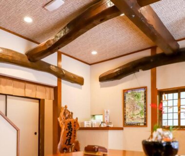 Reception area with exposed wooden beams, shoji window and tatami flooring at Manrikiya in Beppu Kannawa