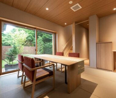 Tatami room with wooden table, chairs and garden view at Hakkaisan Konohanakan in Yamanashi, Chūbu, Japan
