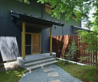 Stone stepping path leading to wooden sliding entrance and fenced garden at Hakkaisan Konohanakan, Yamanashi