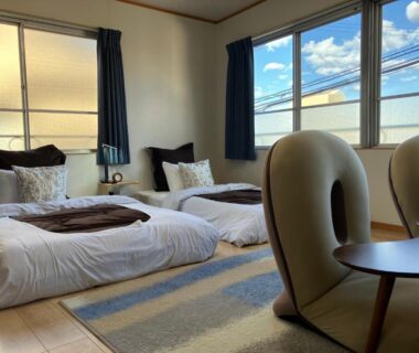 Tatami room with twin futons, low table and chairs at ManrikiyaBekkan in Beppu Kannawa, Ōita