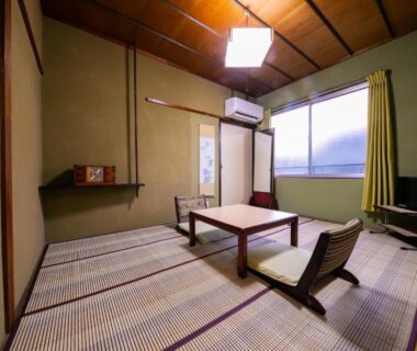 Tatami room with low table and floor chairs at ManrikiyaBekkan in Beppu, Oita
