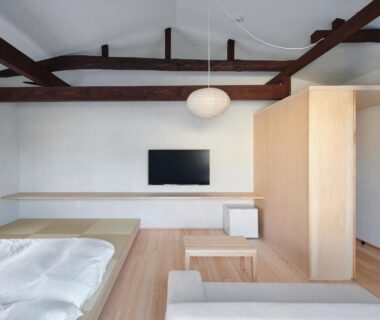 Low futon bed with exposed beams, shoji window and wall-mounted TV at Bettei Nakanoya, Tochigi, Kantō