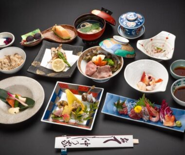Assorted traditional Japanese dishes and sashimi on lacquerware trays for a ryokan meal