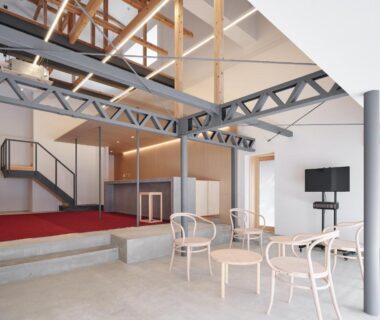 Open modern ryokan lobby with exposed wooden beams, metal trusses, seating and reception at Bettei Nakanoya in Tochigi