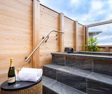 Outdoor stone bath with towel, bottle and glasses at Kappō Ryokan Kiyoto, Chiba Japan