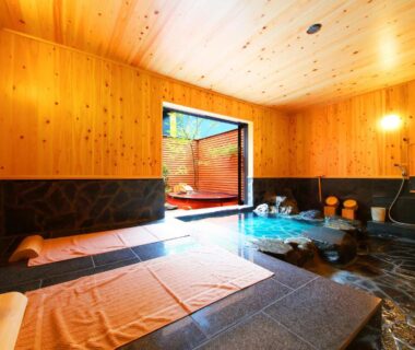 Indoor onsen with cedar walls and stone bath at Shōsei no Yado Shinan, Ōita