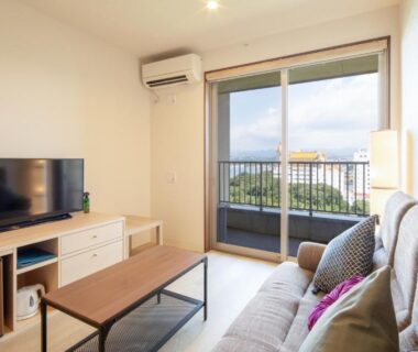 Living area with sofa, TV, coffee table and balcony at Kachōfūgetsu in Nanki Shirahama, Wakayama