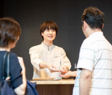 Smiling receptionist greeting guests at Kachōfūgetsu reception, Nanki Shirahama Wakayama