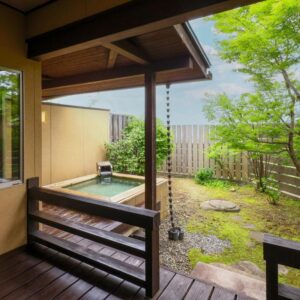Wooden soaking tub on a veranda overlooking a fenced garden at Nagomi no Yuyado Nakayama, Nagano, Chūbu