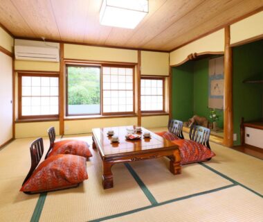 Low wooden table on tatami with zabuton cushions and shoji screens at Nagomi no Yuyado Nakayama Nagano