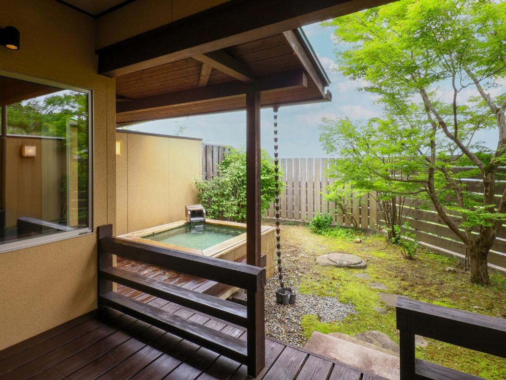 Wooden Outdoor Bath Nagomi no Yuyado Nakayama Nagano Wooden soaking tub on a veranda overlooking a fenced garden at Nagomi no Yuyado Nakayama, Nagano, Chūbu