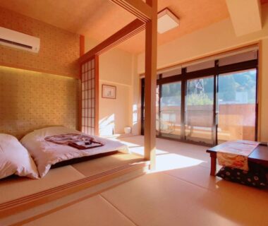 Sunlit tatami room with futons, shoji screens and low table at Waseidō Zen Hyōgo Kansai