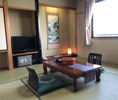 Traditional tatami room with low table and cushions at Ryokan Sakamotoya in Kyoto