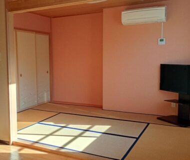 Sunlit tatami room with fusuma doors, television and wall air conditioner at Banshō Nasu-Shiobara in Tochigi