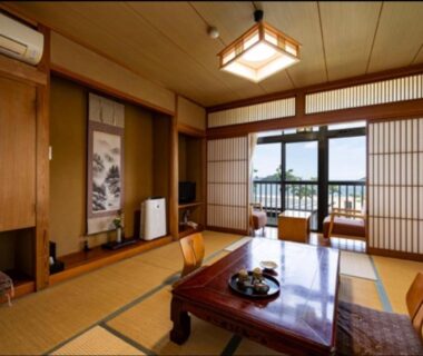 Traditional tatami room with low table and shoji doors at Ryokan Ōmasa in Saga, Kyūshū