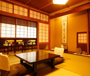 Tatami room with low lacquer table, zabuton cushions, shoji screens and tokonoma at Kinosaki Tsubakino Hyōgo