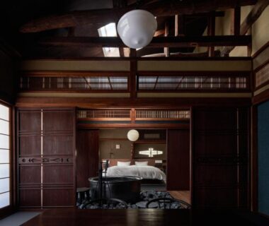 Exposed wooden beams, shoji screens and a bed in a traditional ryokan room in Kinosaki, Hyogo