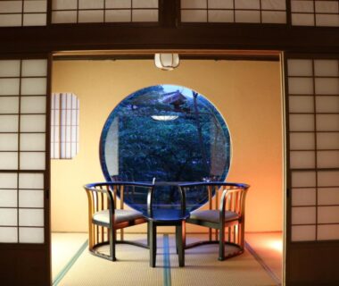Tatami room with circular window and chairs at Jinpyōkaku Honten in Nagano, Chūbu Japan