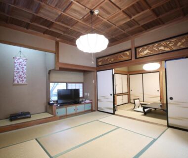 Spacious tatami room with shoji doors and wooden ceiling at Jinpyōkaku Honten in Nagano, Chūbu