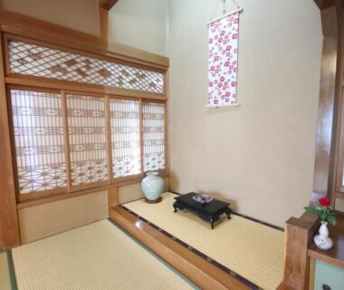 Traditional tatami room with shoji screens, raised alcove and low table at Jinpyōkaku Honten in Nagano