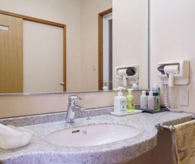 Sink, mirror, hairdryer and toiletries in ryokan bathroom at Shirakawagō no Yu, Chūbu Gifu Japan